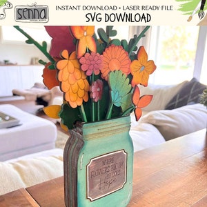 May include: A wooden craft project featuring a mason jar vase with a bouquet of colourful flowers. The jar has a label that reads "Where Flowers Bloom So Does Hope".