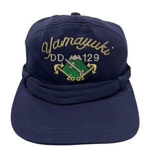 May include: A navy blue baseball cap with a gold embroidered logo that says "Yamayuki DD 129" with a green mountain and two anchors.