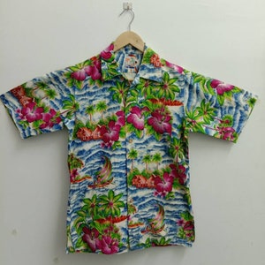 May include: A short-sleeved, button-up shirt with a tropical print featuring palm trees, flowers, and sailboats on a blue and white background.
