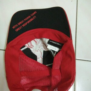 May include: A red and black baseball cap with a mesh back. The front of the cap has the text "With great power comes great responsibility" embroidered in red. The back of the cap has a white tag with black text.