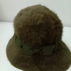May include: A brown fuzzy hat with a green ribbon tied in a bow.
