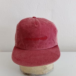 May include: A red baseball cap with a curved brim. The cap features the embroidered text "BANANA REPUBLIC" across the front. The hat is made of a textured fabric and has a rounded crown.