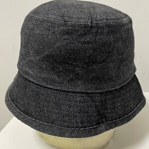 Peut inclure: Un chapeau bob en denim noir avec une large bordure.