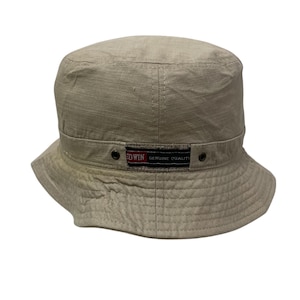 May include: A beige bucket hat with a black band and a red and black label that reads "EDWIN GENUINE QUALITY".