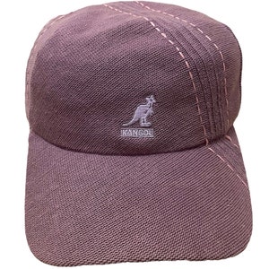 May include: A purple Kangol baseball cap with a pink stitching detail and a white embroidered kangaroo logo.