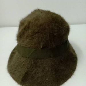 May include: A brown fuzzy bucket hat with a green ribbon around the crown.
