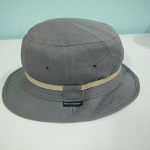 May include: A gray bucket hat with a white band and a black label that reads "MARIO VALENTINO".