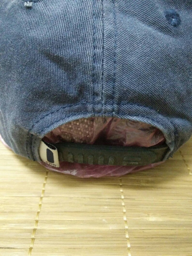 May include: A blue denim baseball cap with a black adjustable strap. The strap has the word "ADIDAS" printed on it.