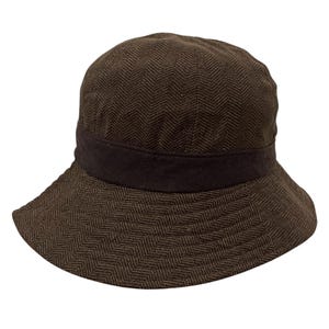 May include: A brown herringbone patterned bucket hat with a brown suede band.