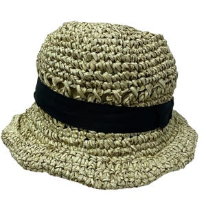 May include: A beige crocheted straw hat with a black ribbon around the crown.