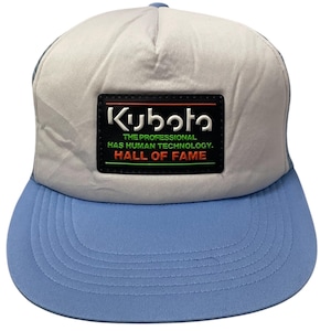 Peut inclure: Une casquette de camionneur grise et bleue avec un patch noir qui dit "Kubota The Professional Has Human Technology. Hall of Fame."