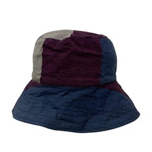 May include: A blue, purple, and gray bucket hat made of a woven fabric.