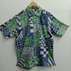 May include: A short-sleeved button-down shirt with a colorful geometric pattern in shades of blue, green, and white. The shirt has a collared neckline and a button-up front.