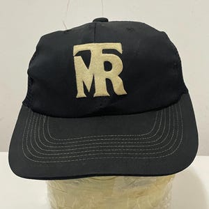 May include: A black mesh trucker hat with a white embroidered "TMR" logo.