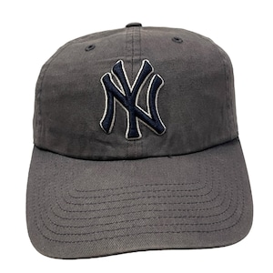 May include: A gray baseball cap with a black and white New York Yankees logo embroidered on the front.