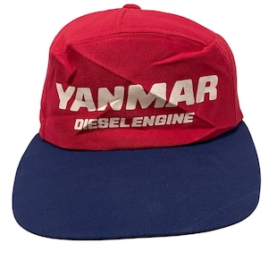 May include: A red and blue baseball cap with the text "YANMAR DIESEL ENGINE" in white.