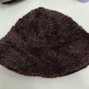 May include: A dark brown fuzzy bucket hat.