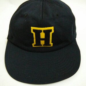 May include: A black baseball cap with a large yellow felt letter "H" on the front.