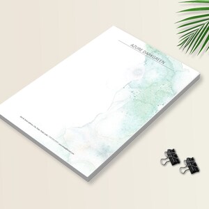May include: A white notepad with a blue and green watercolor design. The notepad has the text "AZURE DARKGREEN" at the top.