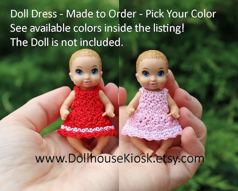 May include: Two crocheted doll dresses, one red and one pink, with white trim. The dresses are made to order and the doll is not included. www.DollhouseKiosk.etsy.com
