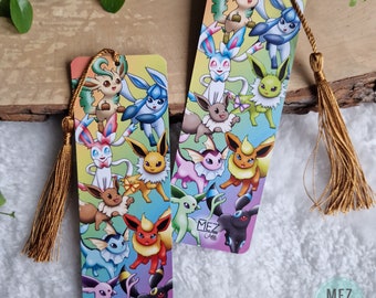 Op de afbeelding: Twee kleurrijke bladwijzers met verschillende evoluties van Eevee. De bladwijzers zijn rechthoekig en hebben een regenboogachtergrond. De tekst "MEZ Arts" is zichtbaar op beide bladwijzers.
