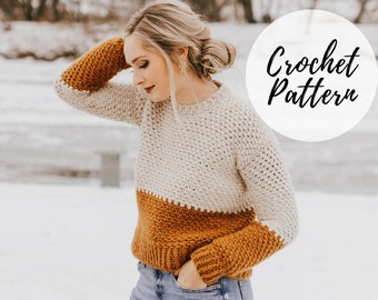 May include: A crochet sweater pattern with a white, beige, and brown color scheme. The sweater has a relaxed fit and long sleeves. The pattern is written in English and includes instructions for making the sweater.