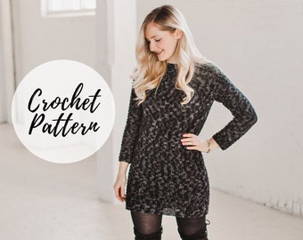 Può includere: Una donna indossa un abito in crochet nero e grigio a maniche lunghe. L'abito è di taglio ampio e presenta un motivo testurizzato. Il testo "Crochet Pattern" è scritto in un cerchio nell'angolo in alto a sinistra dell'immagine.