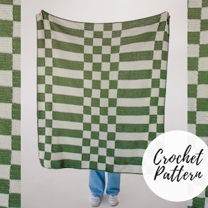 May include: A crochet blanket with a checkered pattern in green and white. The blanket is being held up by a person, and the text "Crochet Pattern" is visible in the lower right corner.