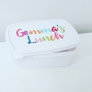 Puede incluir: Fiambrera rectangular blanca con una inscripción colorida que dice "Gemma's Lunch".