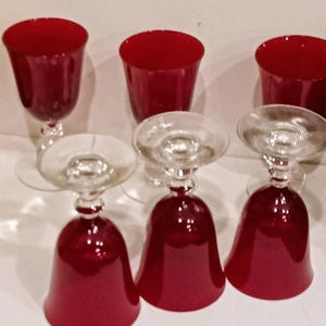 Bicchieri vintage rosso rubino con gambo trasparente. Set di sei bicchieri, mai usati.
