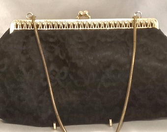 Borsa vintage in tessuto di pizzo con manico a catena dorata e cornice decorativa in metallo.
