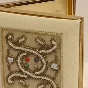 Vintage cigarette case.  Leather bound with beaded pattern on the lid.