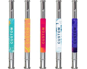 May include: Five silver-colored pens with colorful bands. Each pen has a different band design: teal with white swirls, orange with yellow shapes, red with orange gradient, white with blue swirls, and dark blue with a galaxy pattern. The word "CUSTOM" is printed on each band.