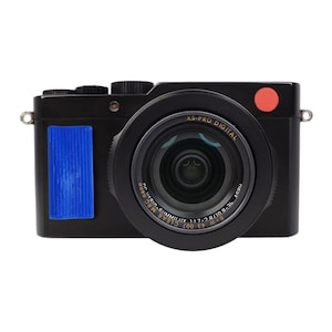 May include: A black digital camera with a red button on the top right corner. The camera lens is a black and silver zoom lens with the text "XS-PRO DIGITAL" and "B+W 43 007 CLEAR MRC SUMMILLUX 1:1.7-2.8/10.9-34 ASPH" printed on it.