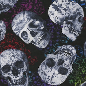 May include: Black fabric with a repeating pattern of white skulls. The skulls are detailed with floral designs. Colorful, ornate flourishes in red, purple, blue, and green are scattered throughout the design. The fabric is suitable for Halloween or gothic-themed projects.