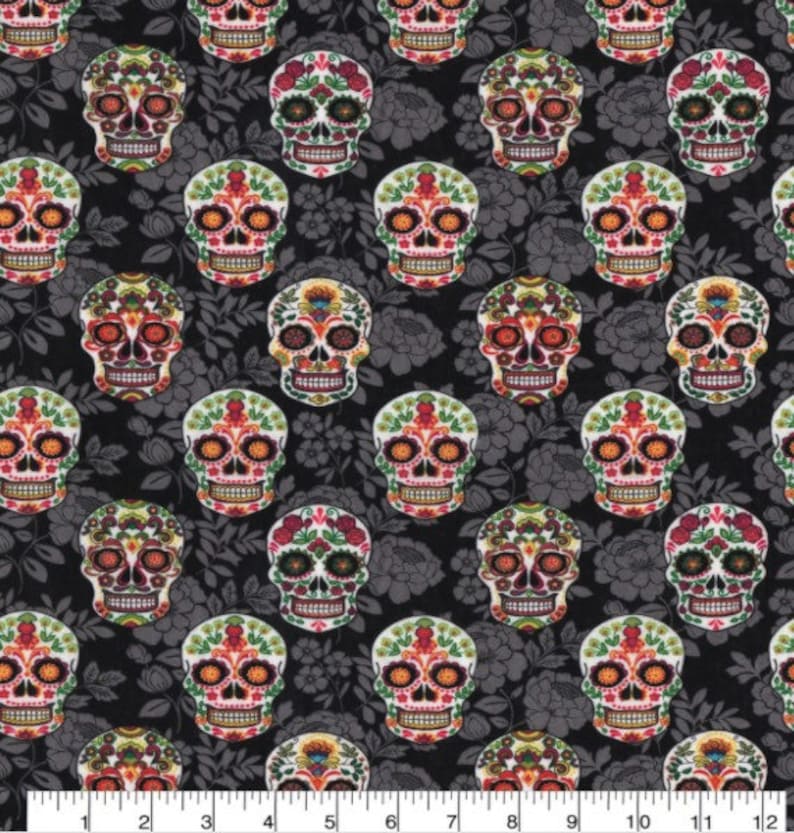 May include: A fabric with a repeating pattern of colorful sugar skull designs. The skulls are decorated with floral and geometric patterns in shades of red, orange, green, and yellow. The background is a dark gray floral print.