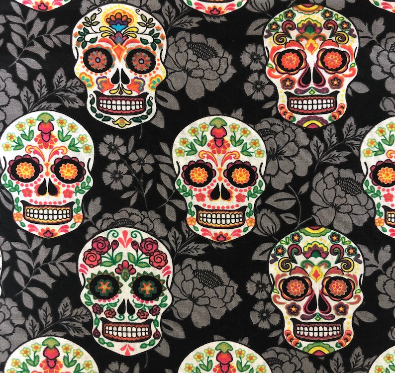 May include: A repeating pattern of colorful sugar skulls on a black background with gray floral accents. The skulls are decorated with vibrant orange, yellow, pink, and green floral designs, perfect for Day of the Dead celebrations.