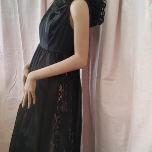 May include: A black sleeveless slip dress with a lace trim. The dress has a fitted bodice and a flowing skirt.