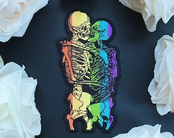 Könnte beinhalten: Regenbogen-Skelett-Paar, das sich umarmt, ein bunter gestickter Aufnäher.