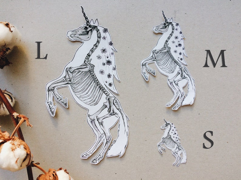May include: Three black and white unicorn skeleton stickers in different sizes, labeled L, M, and S.