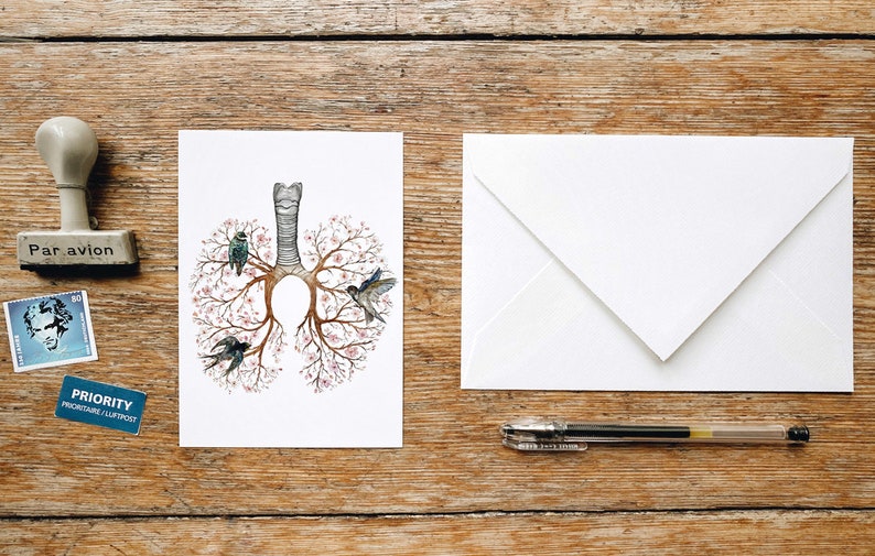 May include: A white card with a drawing of a human lung with pink flowers and birds on the branches. The card is blank and ready for a message.