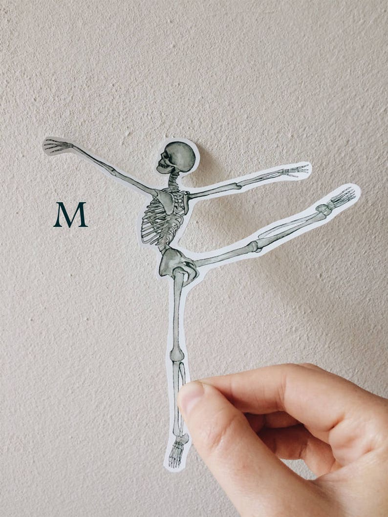 May include: A white sticker of a skeleton in a ballet pose. The skeleton is in a neutral color with gray and black details. The sticker is on a white wall with the letter "M" written in black below it.