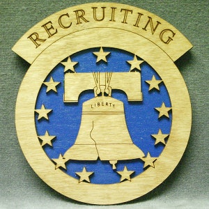 以下が含まれることがあります： 「RECRUITING」という文字が半円形に書かれた木製の看板。青い背景に白い星と自由の鐘の切り抜きが施されています。鐘には「LIBERTY」と刻まれています。