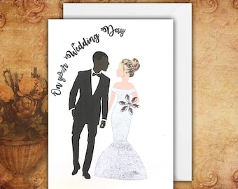 May include: A white greeting card featuring a black silhouette of a person in a tuxedo and a person in a white glittery off-the-shoulder gown with a large floral embellishment. The text On your Wedding Day is printed in black script.