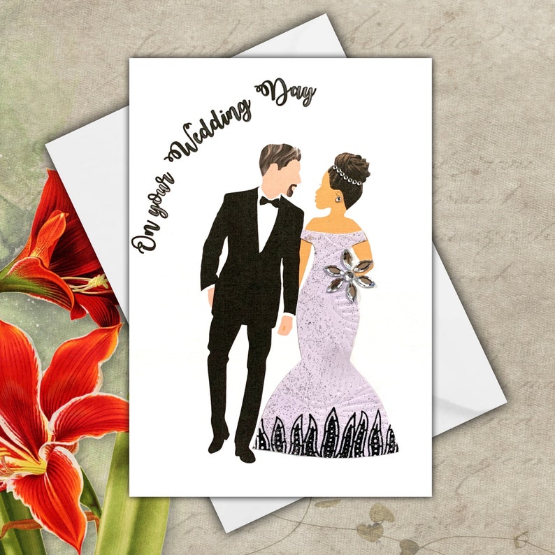 A wedding card with an interracial couple. the white groom is wearing a black tuxedo, he has short brown hair and a goatee. The light skinned black bride is wearing a white glitter hourglass dress , she has a curly top bun hairstyle. The text on the card reads 'On your Wedding Day'.