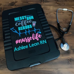 May include: Black medical storage box with a teal, pink, and gray vinyl decal that reads "Messy Bun Coffee Scrubs #nurselife Ashlee Leon RN" and a stethoscope on a wooden surface.