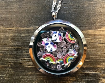 May include: A silver locket necklace with a clear glass insert filled with unicorn and rainbow charms and pink glitter.
