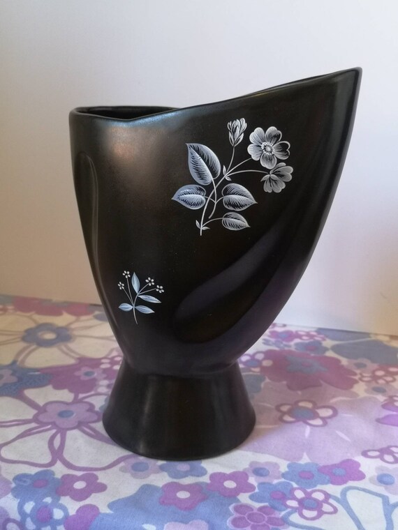 1950 年代のヴィンテージ。白い花柄がデザインされた黒い陶器の花瓶