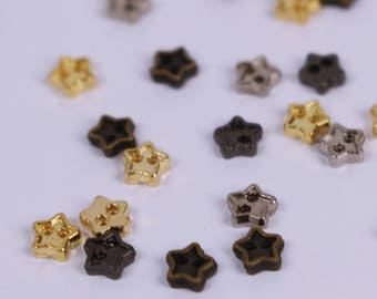 May include: Assortment of star-shaped metal buttons in gold, silver, and black.