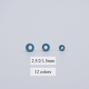 Puede incluir: Tres ojales metálicos azules de diferentes tamaños, 2,5/2/1,5 mm. Los ojales están dispuestos en una fila del más grande al más pequeño. 12 colores disponibles.